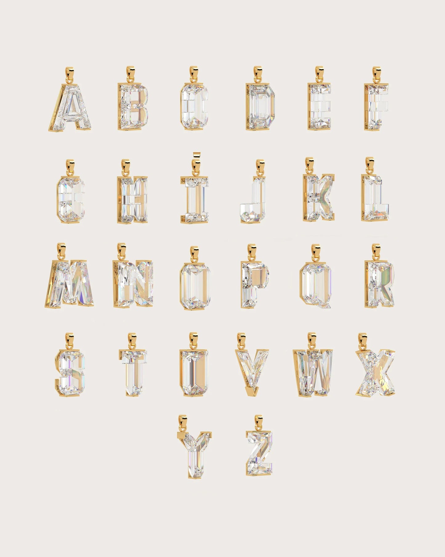A set of gold-tone alphabet pendant charms, from A to Z, arranged in rows on a light beige background. Each letter pendant features a clear, faceted gemstone cut in an emerald or rectangular shape.