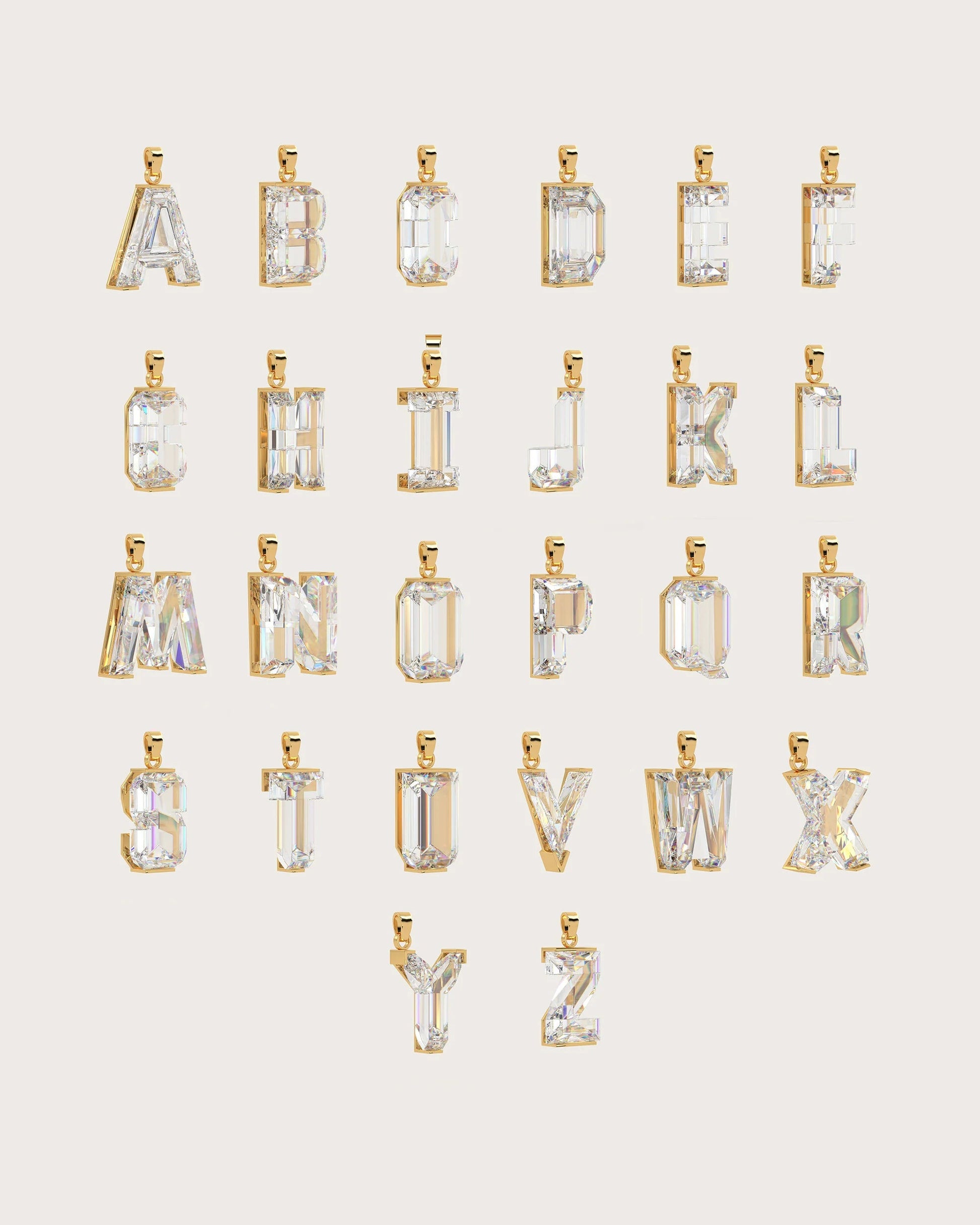 A set of gold-tone alphabet pendant charms, from A to Z, arranged in rows on a light beige background. Each letter pendant features a clear, faceted gemstone cut in an emerald or rectangular shape.